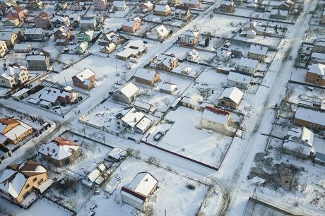 Aerial image of housing with snow on the ground.