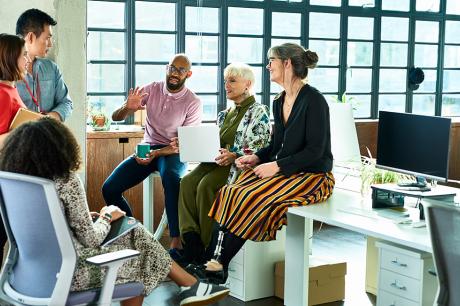 A group of co-workers talking in an office. 
