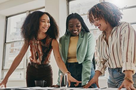 A group of women looking over documents