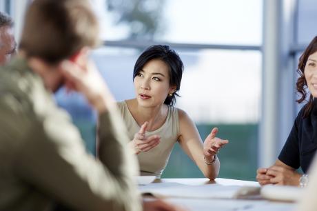 Co-workers talking around a table.