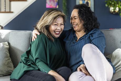 Two women talking on a couch.