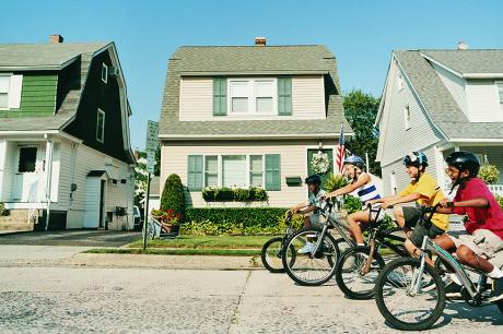 Children riding bikes in a neighborhood street.