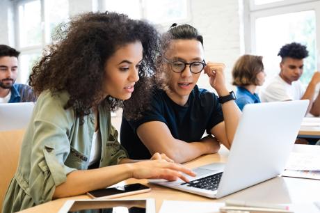 Two students working on a computer together