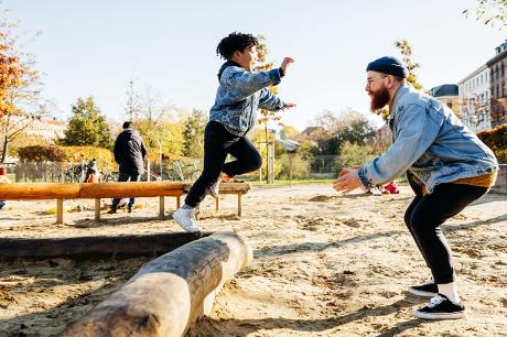 A father playing with his child outside.