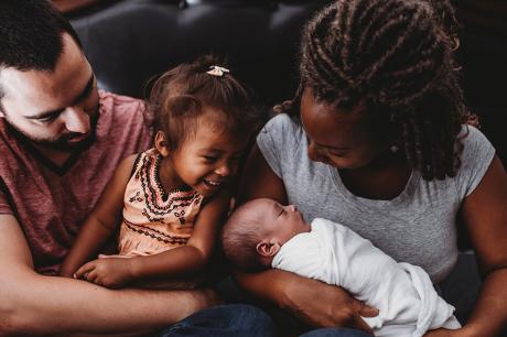 A man and women holding their two young children.