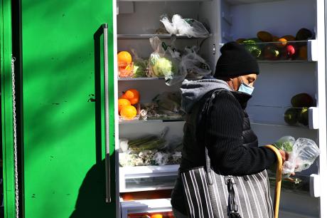 A person picks up food from the Clinton Hill-Fort Greene Mutual Aid group's refrigerator.