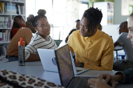 Students working together while on their laptops.