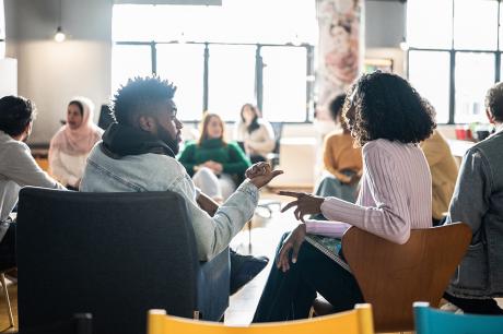 People sitting in chairs in a circle formation.