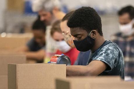 Volunteers pack up boxes of food to be distributed to those in need at the distribution center of the Capital Area Food Bank on April 9, 2020 in Washington, DC.