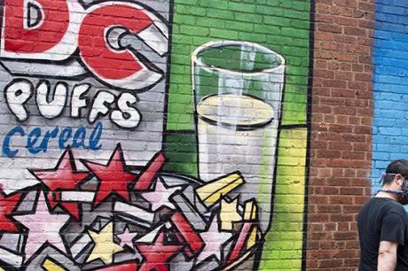 A man walks by new murals depicting different interpretations of DC statehood.