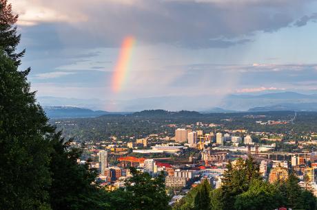 A wide shot of a neighborhood with a rainbow in the back