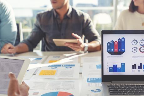 People at work looking at graphs and other documents.