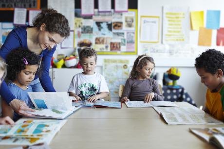 Teacher looking at books with children