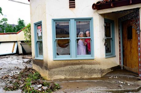 Residents trapped in their home peer out a window while waiting for help in Yucaipa, California.