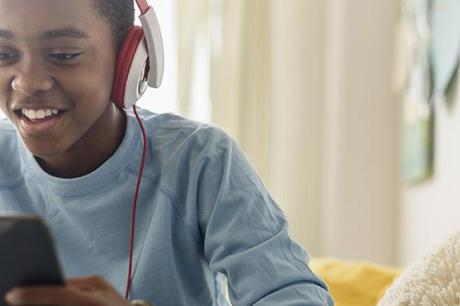Black boy in headphones using digital tablet