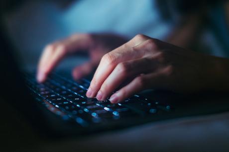 A close up of someone typing on a keyboard.