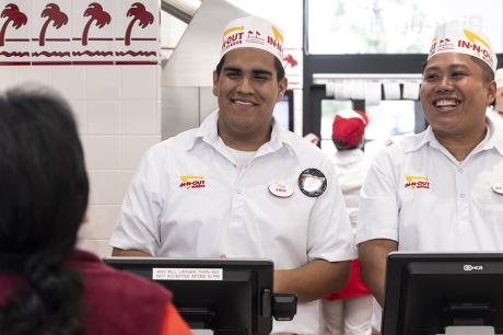 Two in-and-out workers greeting a customer.