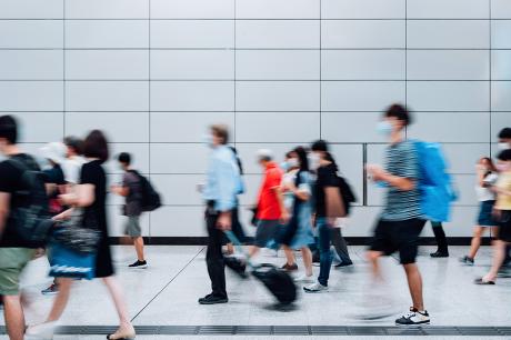 A blury image of people walking down a busy street.