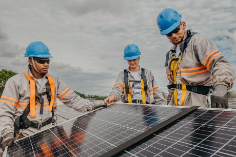 photo of workers working on solar panels