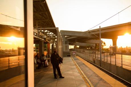 Transit passengers wear face masks as they wait to board the Metro