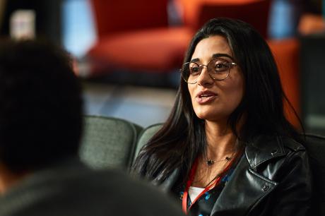 photo of Middle Eastern businesswoman talking to co-workers during break at seminar