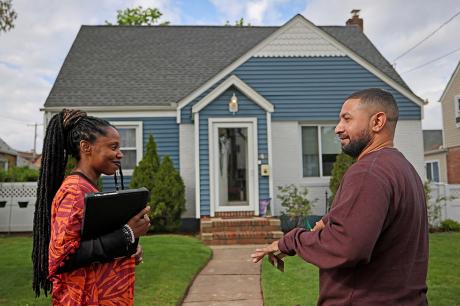 photo of people talking in front of a house