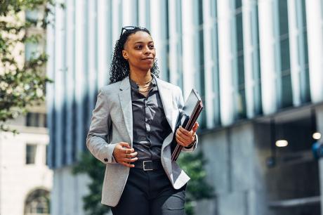Black Business woman holding tablet and portfolio folder