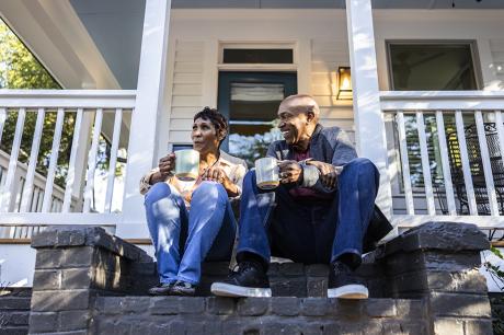 photo of couple sitting on front porch of house