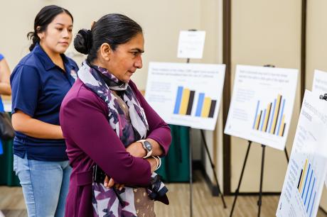 photo of woman looking at poster at meeting