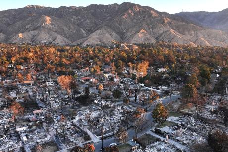 photo of an aerial view of the sun rising beyond homes which burned in the Eaton Fire on January 21, 2025 in Altadena, California