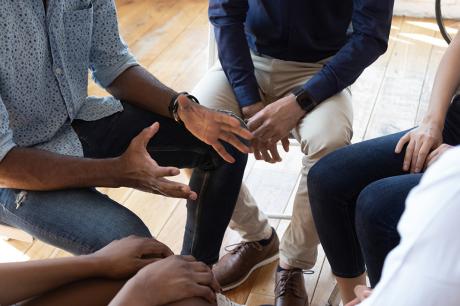 photo of people and counselor speak at group counseling therapy session 