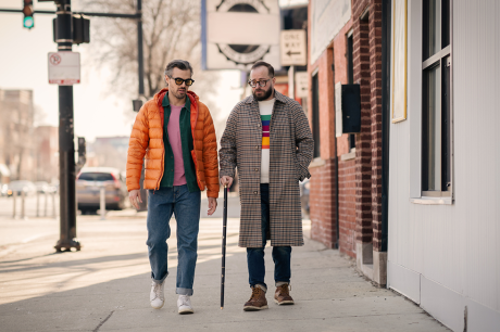 Two men walking down a sidewalk.