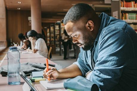 An adult student studies at a library.
