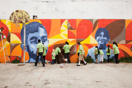 People painting a mural outside.
