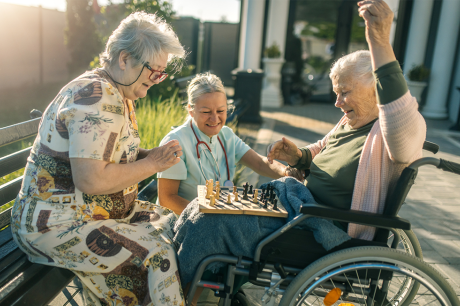 Seniors play chess on a park bench