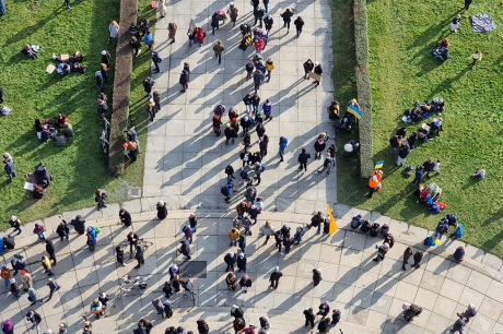 Photo taken from above of dozens of people walking in a park.