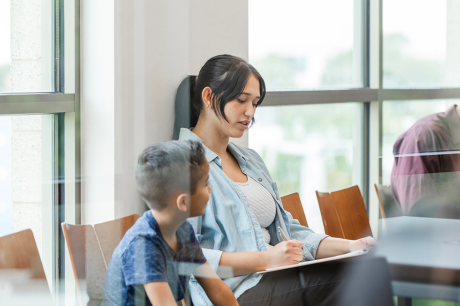 A mother and child in a waiting room for a doctor's visit.