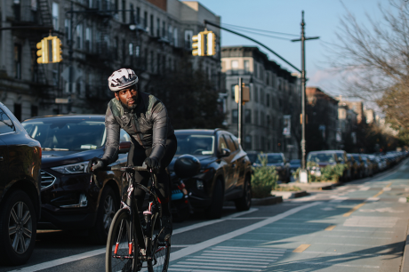 A cyclist riding in a bike line in an urban area.