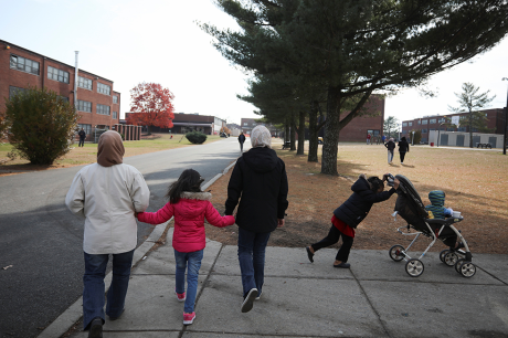 An Afghan refugee family walks past temporary housing in Liberty Village on December 2, 2021 in Joint Base McGuire-Dix-Lakehurst, New Jersey.
