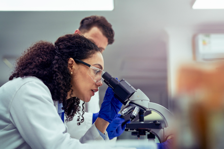 A scientist looking through a microscope.