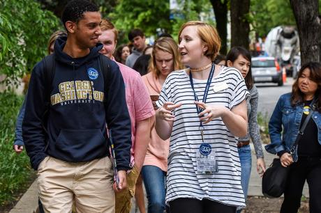 A grouo of college students walking down a street. 