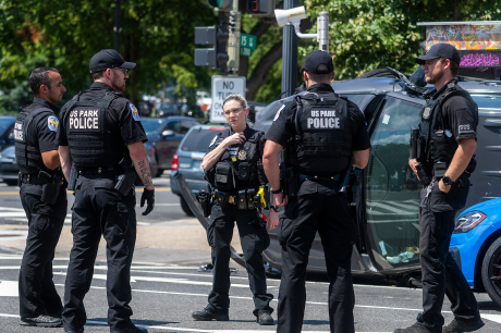 A group of police officers in the middle of a street. 