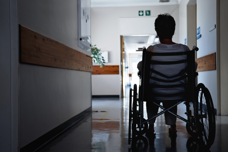 A woman on a wheelchair in a hallway. 