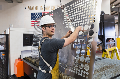 A person with a hard hat working at a factory.