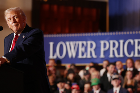 President Trump gives a speech in front of a sign that says “Lower Prices.”