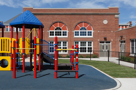 A colorful jungle gym outside an elementary school.
