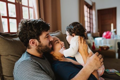 Two young parents holding their baby.
