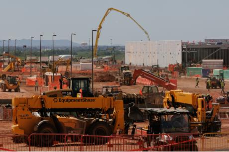 Construction site with heavy equipment and workers.