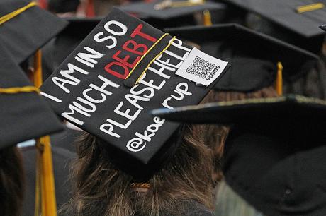College graduation cap reads "I am in so much debt please help"