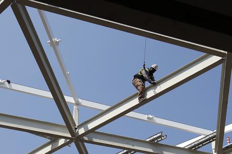 Ironworkers climb a building